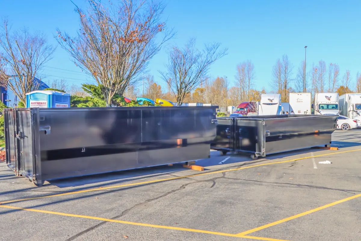 Professional dumpster rental service with roll-off container on residential driveway in Bel Aire